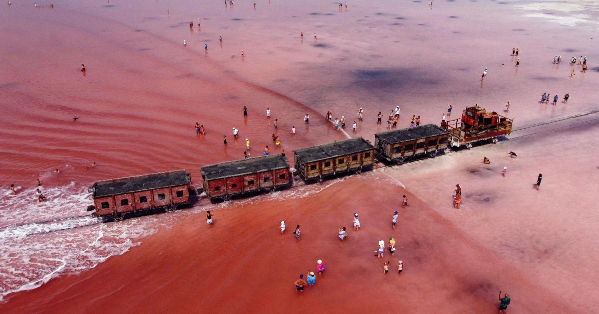 La saliera: il treno merci che attraversa un lago rosa della Siberia